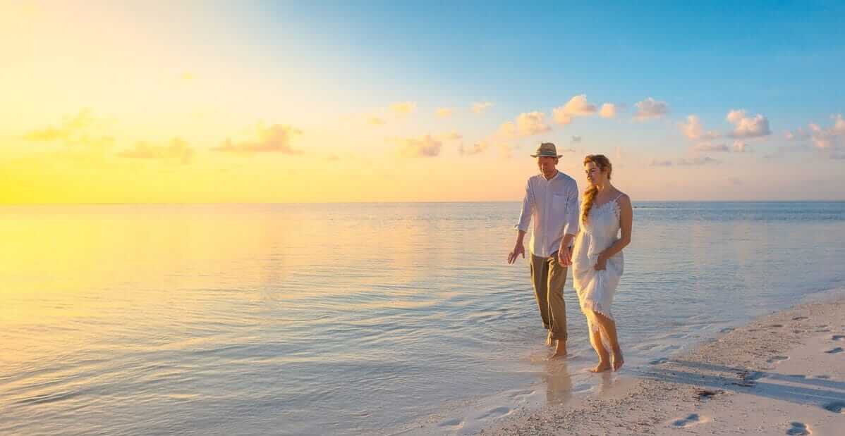 couple walking on the beach at sunset