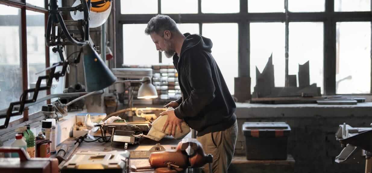 man standing up working at bench