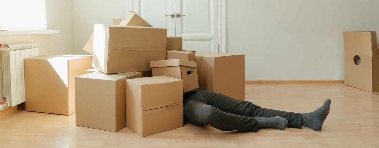 person in apartment covered in boxes