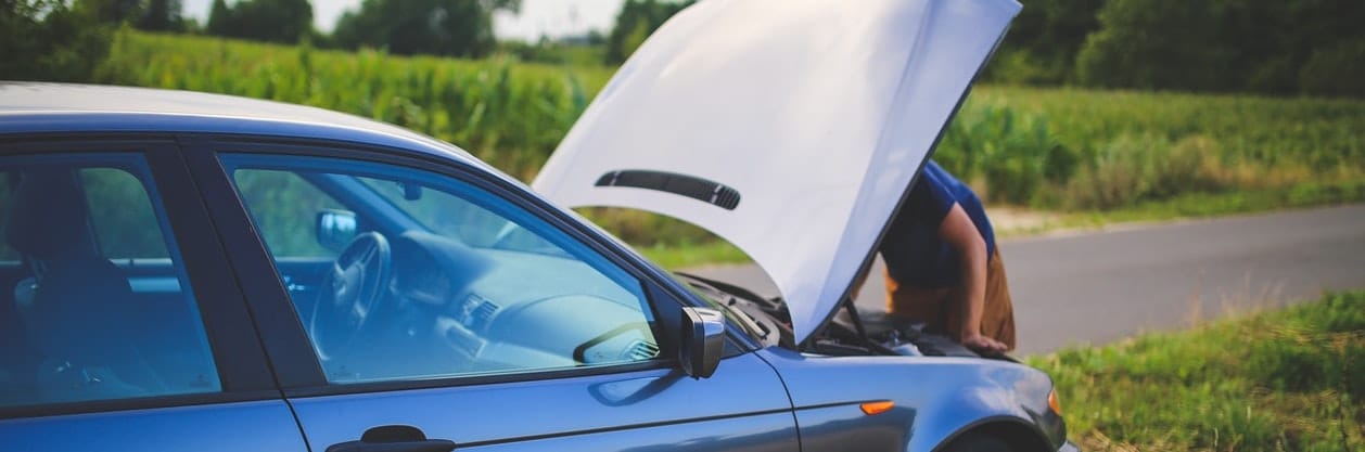 man looking under car bonnet